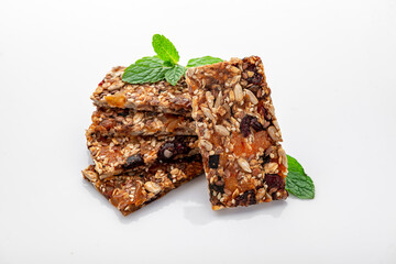 Energy granola bars with different seeds, nuts and dried fruits and berries on a white background