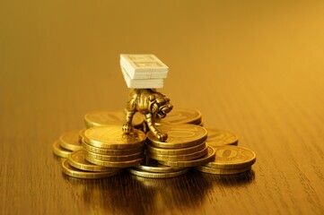 A metal tiger with a wad of dollars on the table in close-up.