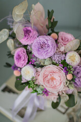 Beautiful spring bouquet in pink and purpl color, in round ceramic vase. Arrangement with Peonies roses. Decorative flowers in a round vase.
