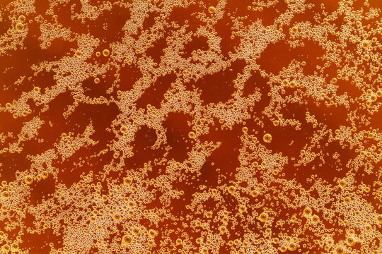 Beer foam bubbles. Bubbles irradiated with light. Roughened surface.