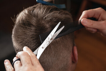 barber cut man's hair, modern haircut with scissors..