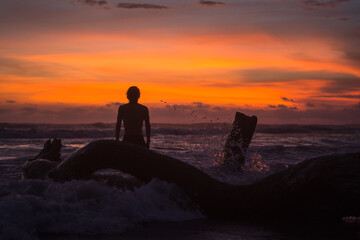 silhouette of a person sitting on a rock