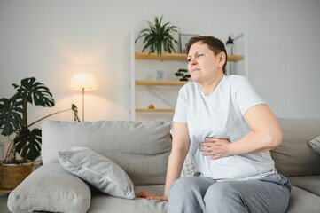 Sick upset middle aged lady hold belly suffer from abdomen ache concept, mature old adult woman...