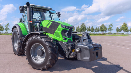 Obraz premium powerful agricultural tractor on the site against the blue sky