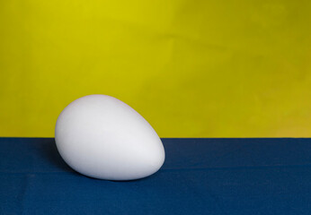 White egg on a yellow-blue background.