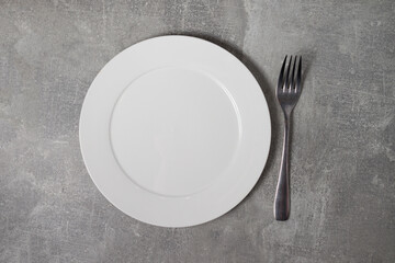 empty white plate and fork on the table
