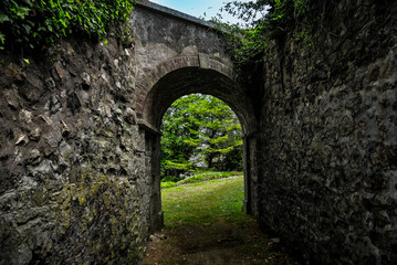 Fototapeta na wymiar Stone archway leading to the park