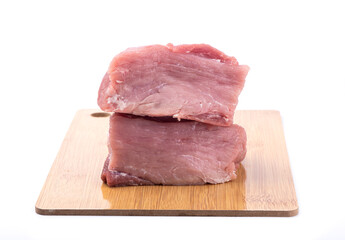 Two pieces of fresh juicy pork meat on cutting board over white background.