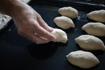 Obraz premium Woman cooking pies at home. Cooking and baking at home.