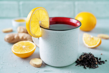 Fototapeta na wymiar Cup of black tea with honey, lemon and ginger