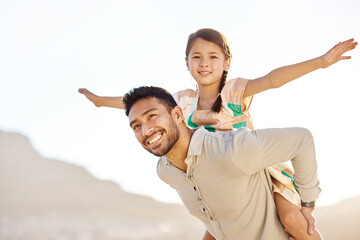 Flying high with daddy. Cropped shot of a handsome young man piggybacking his daughter on the beach.