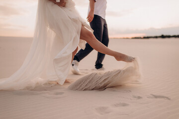 Fototapeta na wymiar feet of a couple of lovers on the white sand on the beach