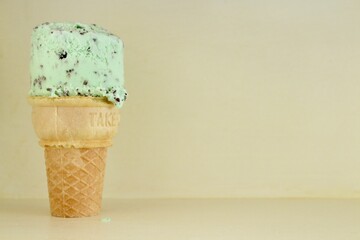 Mint Chip ice cream cone against neutral background