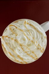 Caramel drizzle whipped cream on espresso drink in ceramic cup