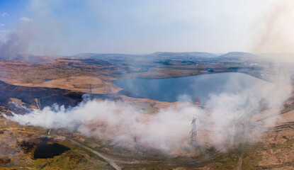 Aerial panoramic view of a large grassfire on moorland in Wales