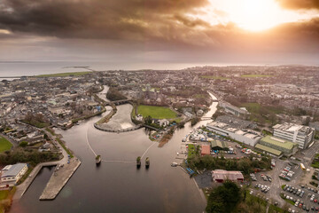Aerial drone view on Galway city. River Corrib and rowing club. Dark dramatic sunset sky. Nobody. Popular tourist and business city with rich history. - obrazy, fototapety, plakaty