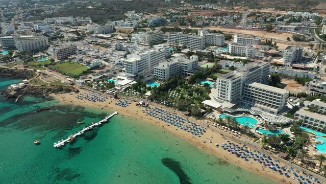 Flying over the Mediterranean Sea beach and hotels in tourist Protaras, Cyprus, aerial video