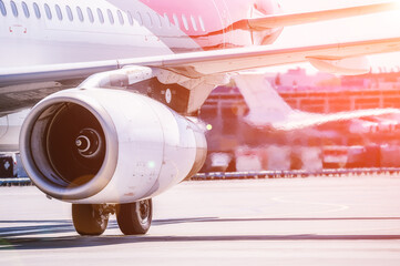 An aircraft jet engine and a jet of hot exhaust gas close-up. Passenger plane on the background of...