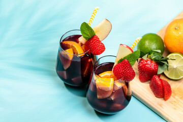 Preparation of traditional Spanish summer drink Sangria with fresh fruits, red wine and ice cubes.
