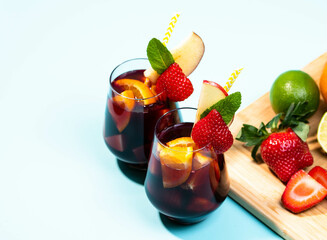 Preparation of traditional Spanish summer drink Sangria with fresh fruits, red wine and ice cubes.