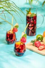Preparation of traditional Spanish summer drink Sangria with fresh fruits, red wine and ice cubes.