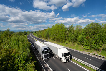Overtaking trucks on the highway in the forested landscape