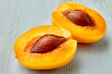 Two halves of a yellow apricot close up