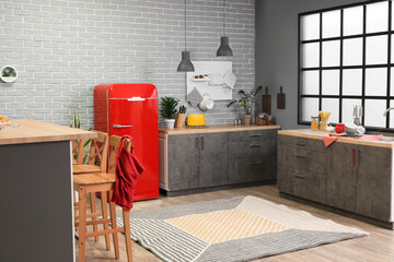 Interior of modern kitchen with stylish refrigerator and counters