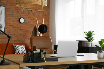 Workplace with modern laptop and organizer with stationery supplies in office