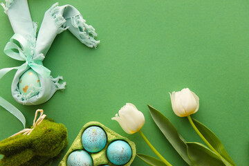 Composition with Easter eggs, bunny and tulip flowers on green background