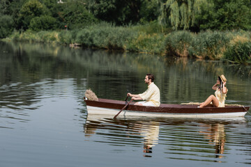 side view of couple having romantic boat ride on lake.