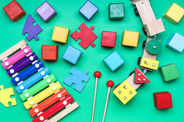 Obraz premium Wooden cubes with puzzle pieces and xylophone on color background
