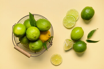 Basket with ripe limes and lemon on color background
