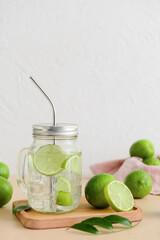 Mason jar with cold water and limes on table