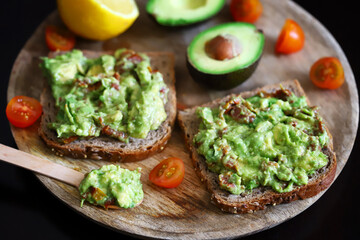 Selective focus. Macro. Guacamole toasts on a wooden board. Healthly food. Keto diet.