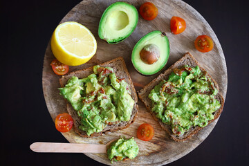 Selective focus. Macro. Guacamole toasts on a wooden board. Healthly food. Keto diet.