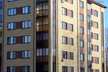 Fototapeta na wymiar New apartment building with glass balconies. Modern architecture houses. Large glazing on the facade of the building.