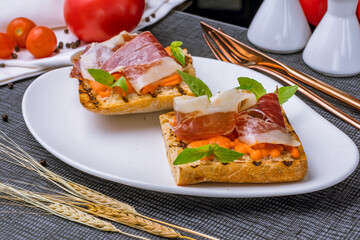 Bruschetta with jamon and pumpkin sauce with basil macro close up
