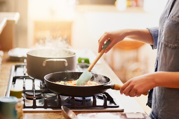 Working some magic in the kitchen. Cropped shot of a young woman preparing a meal at home.