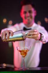 Bespoke cocktails just for you. Shot of a bartender pouring a drink into a glass in a nightclub.