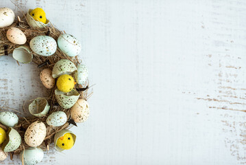 Easter background wreath with Easter eggs and chicks. Top view with copy space.