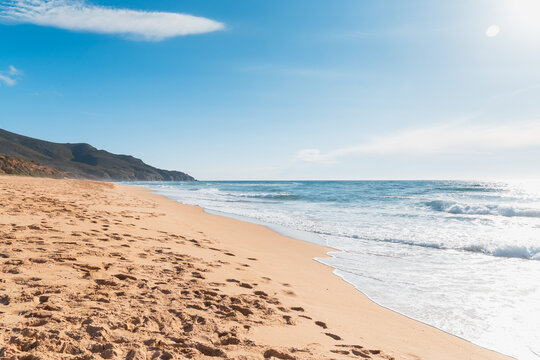 View of mountains and sand from the beach of Scivu, Marina di Arbus, Sardinia, Italy