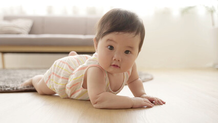 Fototapeta premium リビングを這いずる赤ちゃん