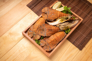 Steamed Flathead lobster with butter and lemon, Boiled Flathead lobster on wooden plate on wooden...
