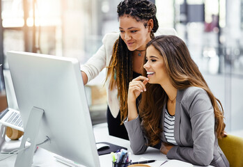 That looks good. Cropped shot of two attractive young businesswomen working at a desk in their office.