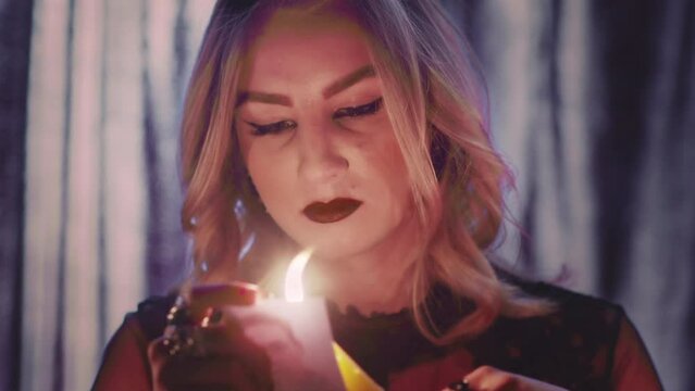 Witch fortune teller psychic moves candle near photo with lost person, and then dripping paraffin on it