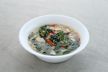 Tumis or Ca Kangkung Terasi with Tempeh, is one of Indonesian food. Served on white bowl on grey background. 
