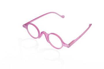 Close-up and spot focus of pink eyeglass frames on white background.