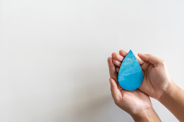Adult hands holding the water drop on white background.
