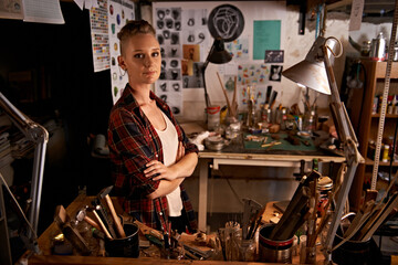 Organized chaos. Shot of a beautiful young woman sitting in a workshop.